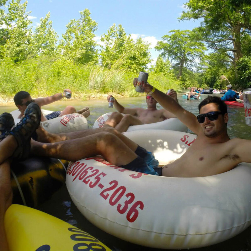 Guy cheersing on the river with a beer